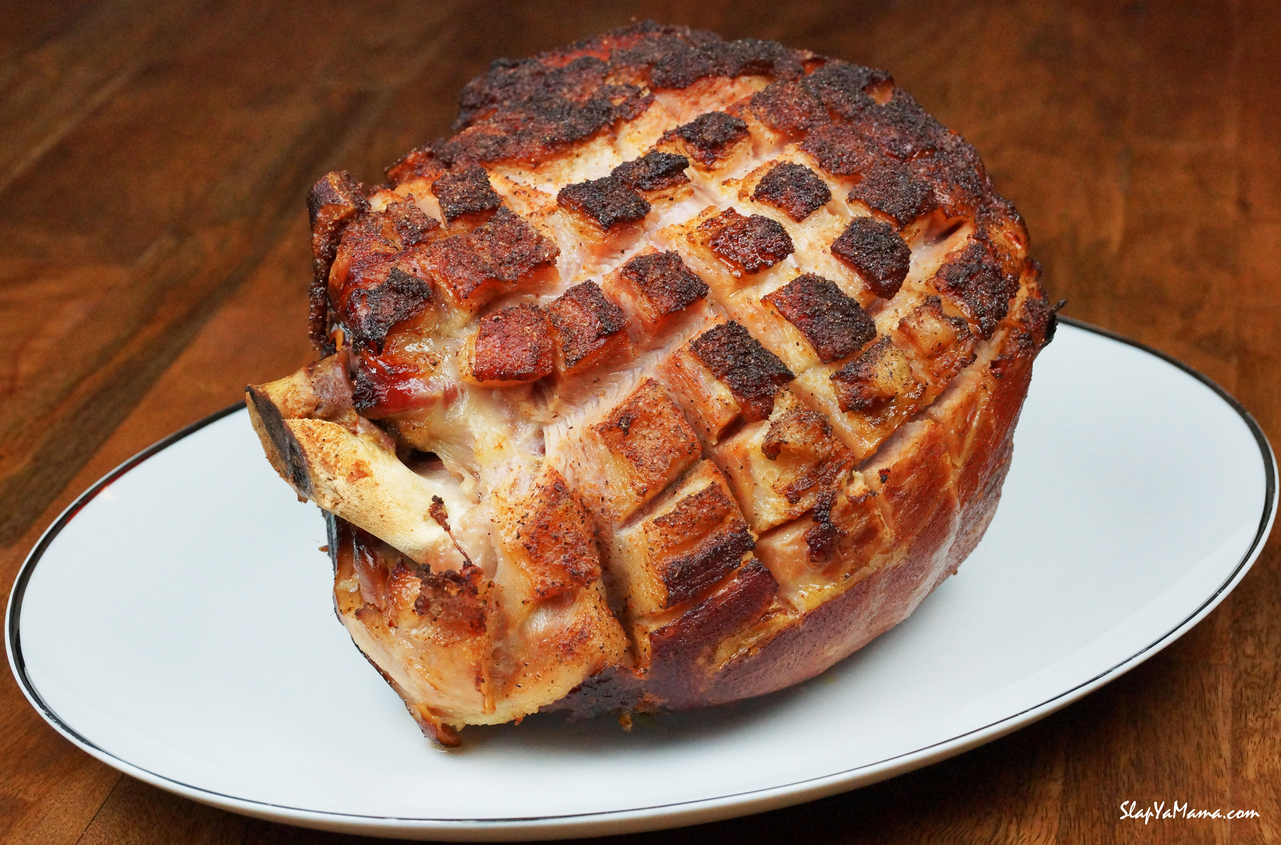 A Roasted Ham sitting on a white plate