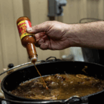 pot of sausage and rice, with slap ya mama hot sauce